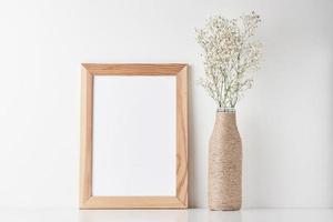 Workspace desk with empty frame and flower in vase photo