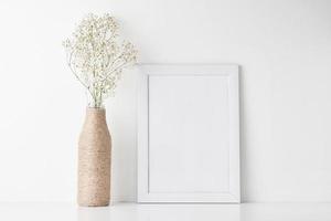 Workspace desk with empty frame and flower in vase photo