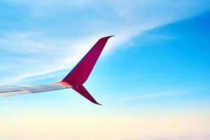 ala de avión y cielo azul con nubes, vista desde la ventana del avión foto