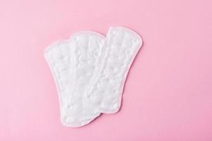 Sanitary pads on a pink background, top view photo
