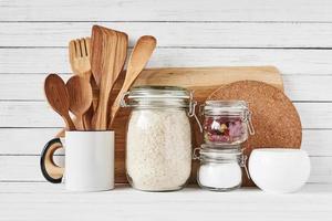 herramientas de cocina y tabla de cortar en mesa blanca foto