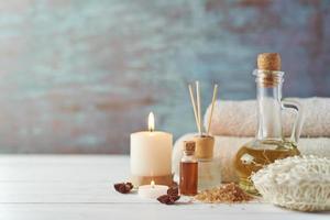 Towels, candle and massage oil on white table photo