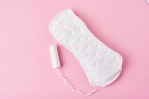 Sanitary pad and menstrual tampon on a pink background photo