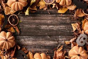 Frame border with autumn fall leaves on a dark wooden table photo