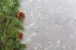 Christmas gray cement wooden background with fir tree frame and cones copy space. top view empty space for your design photo