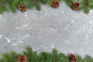 Christmas gray cement wooden background with fir tree frame and cones copy space. top view empty space for your design photo