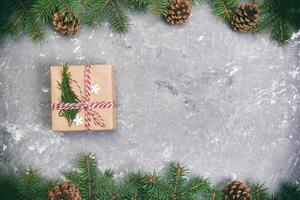 Christmas background with fir tree and gift box on gray cement rustic vintage table. Top view with copy space for your design