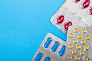 Colored pills, tablets and capsules on a blue background. Medicine and health. photo