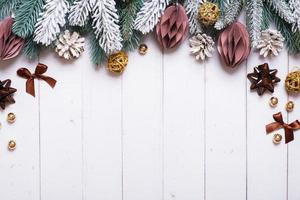 Christmas holiday background with flat lay snow pine trees, paper Christmas toys on wooden background. Copy space. photo