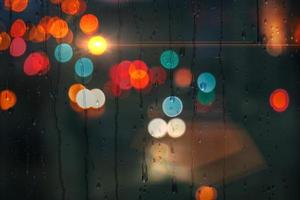 raindrops on the window in rainy days and street lights background photo