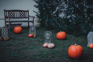 halloween decoration with pumpkins and tombstones in a garden photo