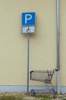 shopping cart in front of a parking sign photo