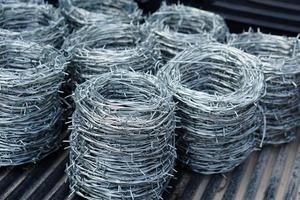 Rolls of barbed wire. Barbed wire is used for make fences , secure property and make border to show the territory of  area. photo