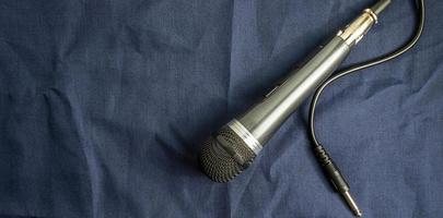 Top view of microphone connected by cable on blue background. photo