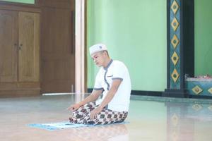 Young asian muslim praying in the mosque photo