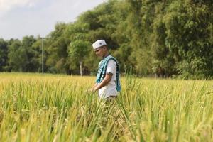 joven musulmán asiático en el campo de arroz foto