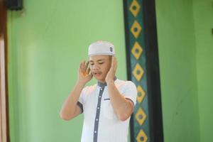 Young asian muslim praying in the mosque photo