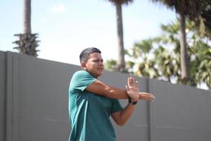 Young asian boy warming up for jogging in the morning photo