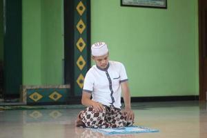 Young asian muslim praying in the mosque photo