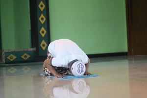 joven musulmán asiático rezando en la mezquita foto