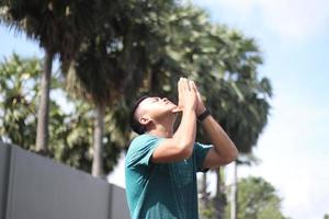 Young asian boy warming up for jogging in the morning photo