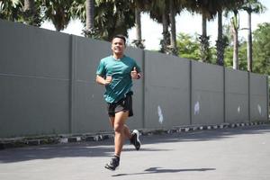 Young asian boy warming up for jogging in the morning photo