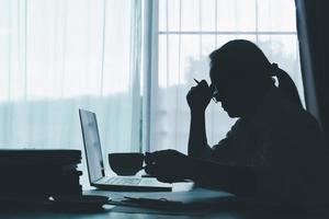 Stress business woman person from hard work, depression in office. Tired and anxious employee female with unhappy at problem job. young businesswoman sitting sad front of laptop computer on desk. photo