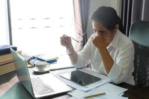 estrés mujer de negocios persona de trabajo duro, depresión en el cargo. mujer empleada cansada y ansiosa con infeliz en el trabajo problemático. joven empresaria sentada triste frente a la computadora portátil en el escritorio. foto