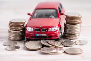 bangkok, tailandia, 1 de junio de 2022 coche en pila de monedas. Préstamo de automóvil, finanzas, ahorro de dinero, seguros y conceptos de tiempo de arrendamiento. foto