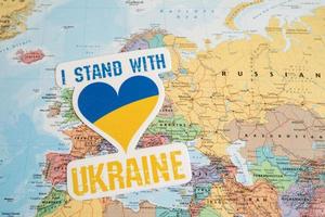 Bangkok, Thailand - September 1, 2022 I stand with Ukraine text with heart flag on world map, stop war with Russia concept. photo