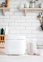 Electric rice cooker on wooden counter-top in the kitchen photo