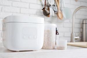 Electric rice cooker on wooden counter-top in the kitchen photo