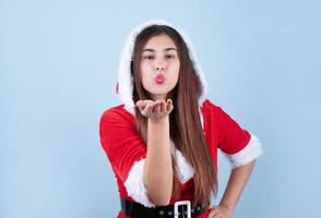closeup of caucasian woman wearing santa clothes blowing kiss photo