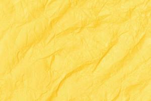 Crumpled paper abstract background texture. Yellow color. Full frame