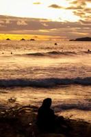 río de janeiro, rj, brasil, 2022 - personas en silueta miran la puesta de sol en arpoador rock, playa de ipanema foto