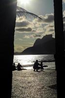 río de janeiro, rj, brasil, 2022 - personas en silueta miran la puesta de sol en arpoador rock, playa de ipanema foto