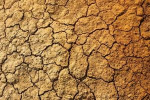 Dry cracked orange stony soil, top view. photo