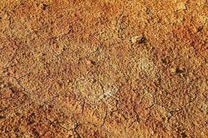 Dry polluted orange stony soil, top view. photo