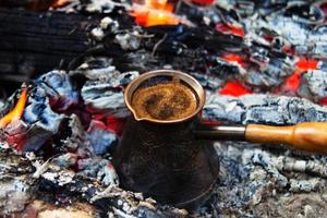 cezve de metal con café con sabor caliente en un primer plano de hoguera. foto