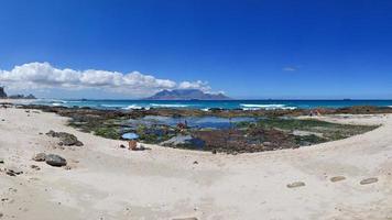 Scenic view of Cape Town with Table Mountain on the horizon and beach on the foreground photo