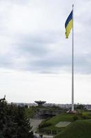 la bandera ucraniana ondeando en el viento, cerca de la famosa estatua de la patria. la bandera nacional más grande de ucrania en el cielo azul. hermoso paisaje de otoño. ucrania, Kyiv - 9 de octubre de 2022. foto