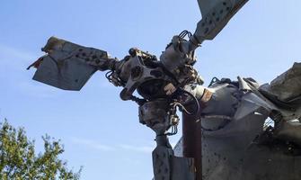 Detail of the Mi-24 helicopter. Remains of a destroyed Russian Air Force combat helicopter Hind Crocodile. Engine rotor, blades, tail, wreckage of a crashed military attack helicopter close-up. photo