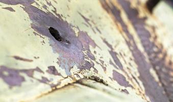 Hole or hole, armor deformation from a projectile close-up. Damaged armor of a Russian armored personnel carrier by shell fragments. War in Ukraine. Russian combat vehicle with holes in the armor. photo