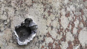 guerra en ucrania, un agujero en la armadura del bmp, armadura perforada. textura de metal blindado de camuflaje verde con daños y agujeros. vehículo blindado militar destruido. foto