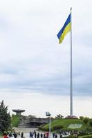 la bandera ucraniana ondeando en el viento, cerca de la famosa estatua de la patria. la bandera nacional más grande de ucrania en el cielo azul. hermoso paisaje de otoño. ucrania, Kyiv - 9 de octubre de 2022. foto