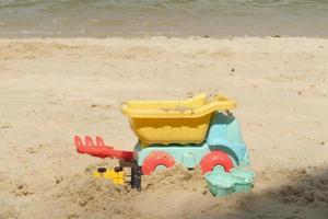 multi-colored plastic toys on a large sea sandy beach photo