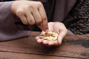 women eating almond and cashew nuts photo