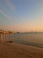 la vista nocturna y la puesta de sol desde la playa de jeddah son muy hermosas. multitudes de personas acuden a la playa de jeddah para ver la puesta de sol. foto