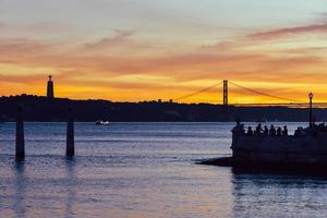 People enjoying the sunset view over the Tagus river in Lisbon photo