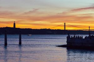 gente disfrutando de la vista del atardecer sobre el río tajo en lisboa foto